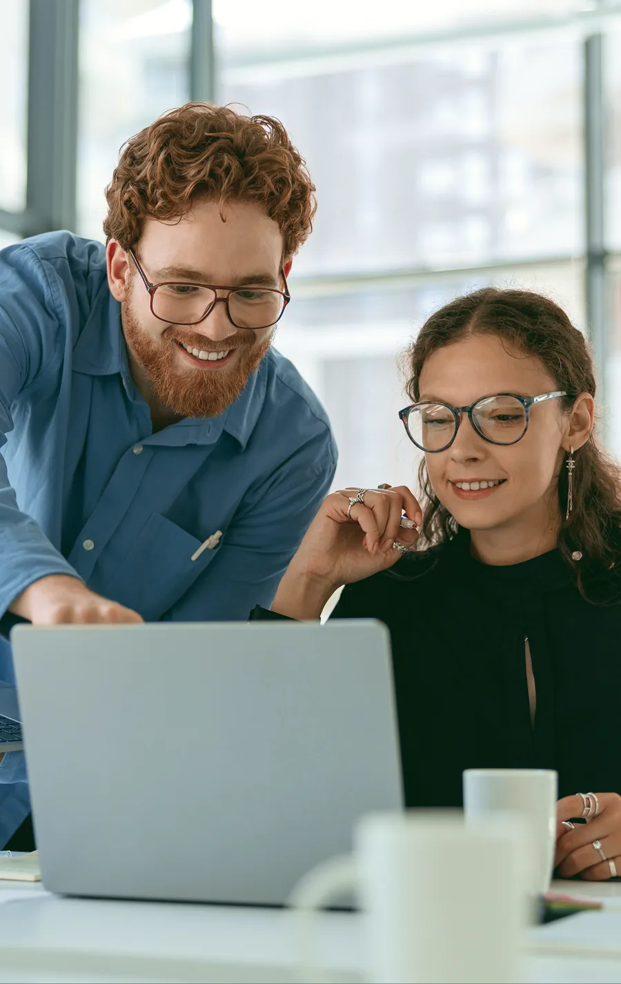 A Sope consultant working through a real task with a colleague at her laptop